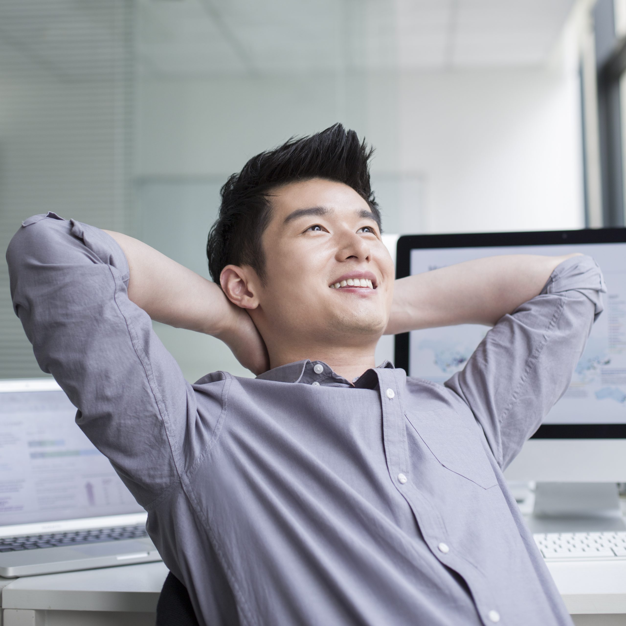 Young Chinese businessman thinking in office